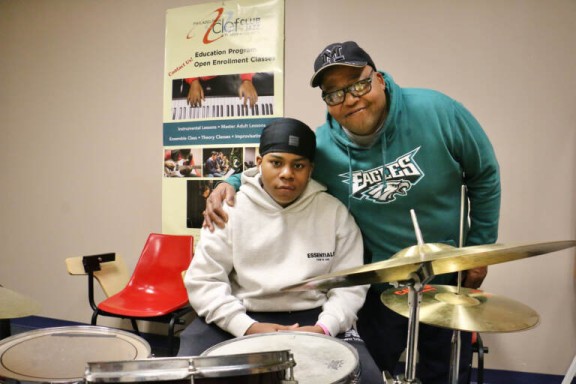 Father and son behind a drum set