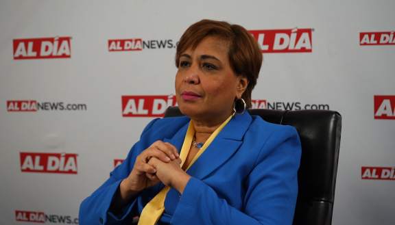 Maria Quiñones-Sánchez in front of AL DÍA banner