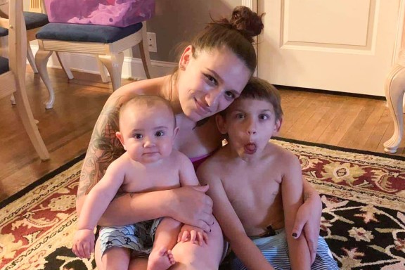 Amanda Cahill smiling, hugging her two young children