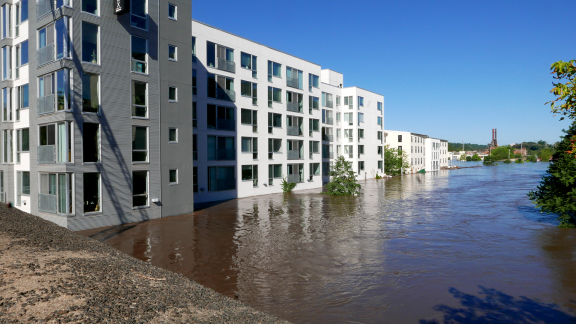 Large, white apartment complex with its first floor flooded