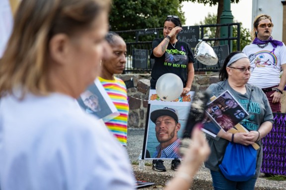 Mourners holding pictures of people who have died from addiction