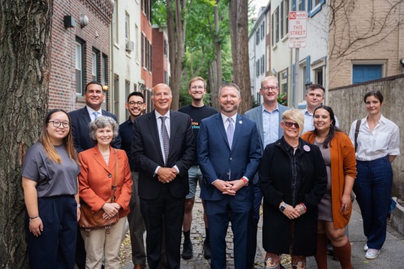 12 smiling local Philadelphia leaders on a historic street