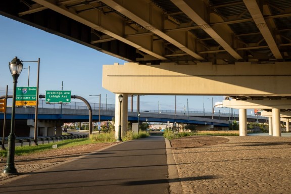 Clear paved walking path under I-95 overpass