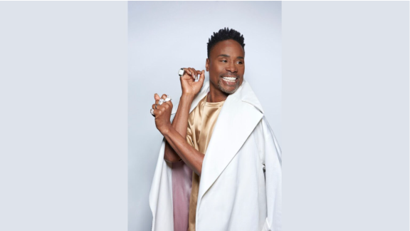 Photo of Billy Porter smiling in a white coat