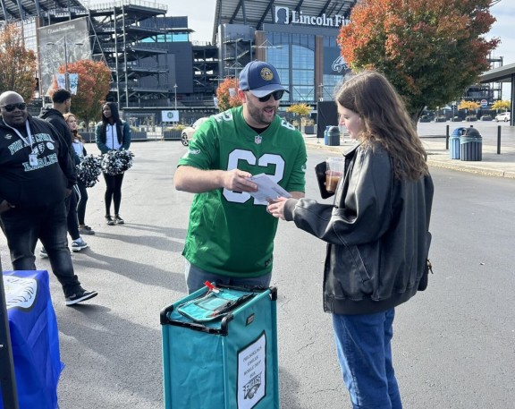 Two people talking at a mail ballot drop off event at Lincoln Financial Field