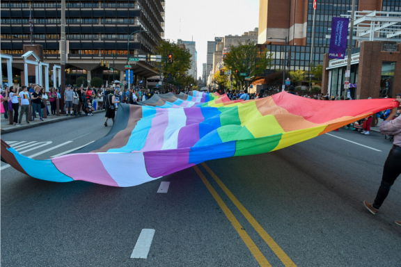 400 foot pride flag being carried by OURfest parade marchers down a Philadelphia street