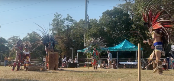 Indigenous people dancing in traditional feathered headdresses at Indigenous Peoples Day in Philly