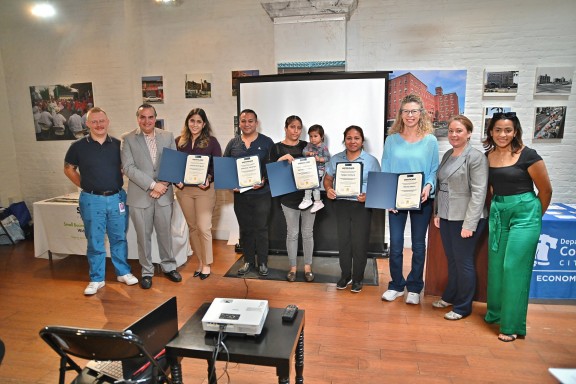 People holding certificates after completing a Department of Commerce workshop