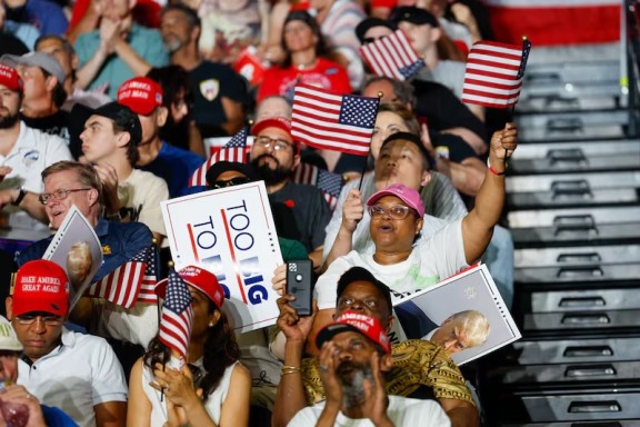 People cheering in stands at a Trump rally