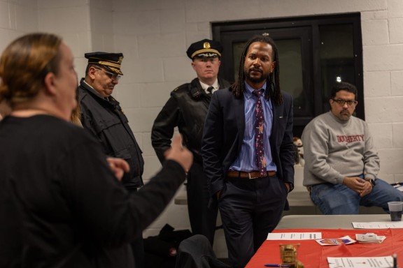 Woman addressing Chief Public Safety Director at a community meeting