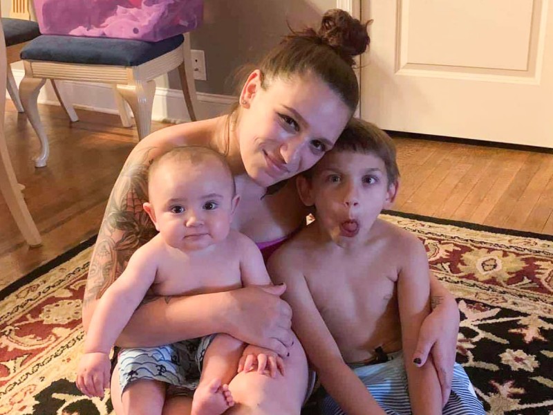 Amanda Cahill smiling, hugging her two young children