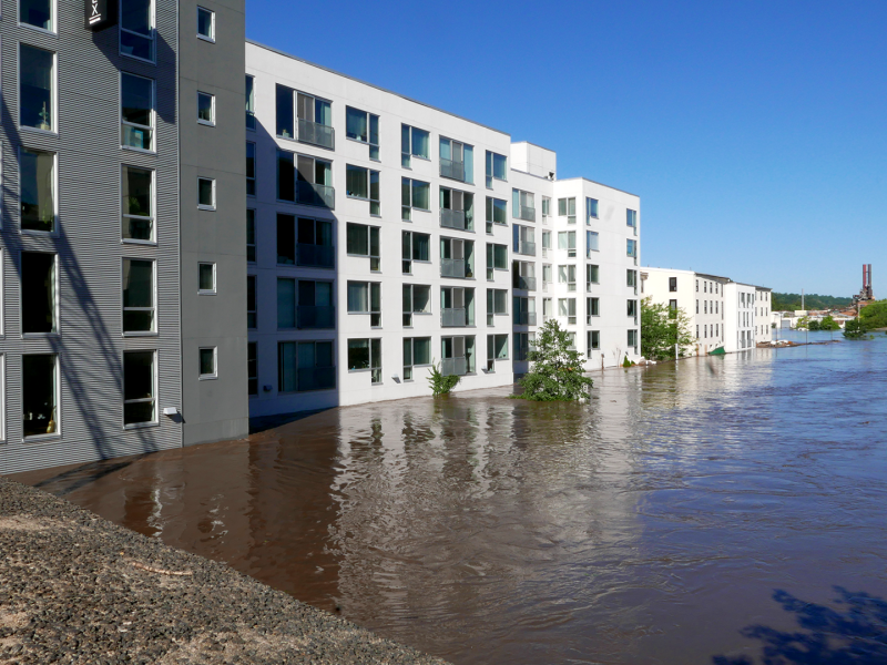 Large, white apartment complex with its first floor flooded