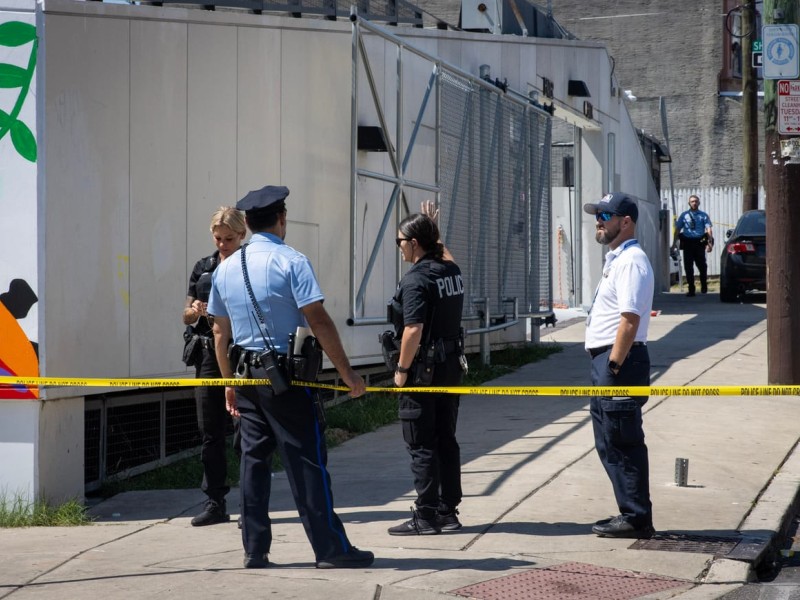 Police officers standing on a sidewalk with caution tape in front of them