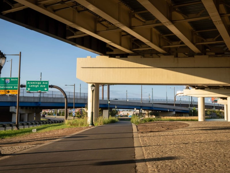 Clear paved walking path under I-95 overpass