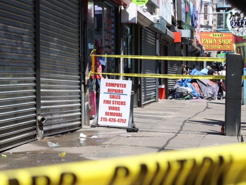 Streetscape with closed storefronts and police caution tape