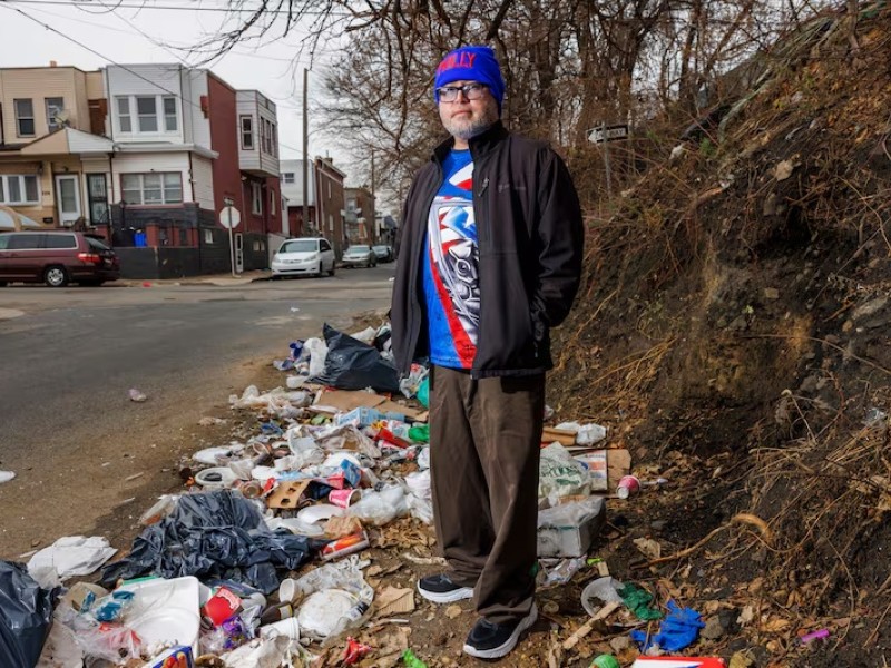 A man standing on a dumping site in the Kensington neighborhood of Philadelphia