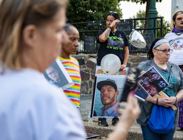 Mourners holding pictures of people who have died from addiction