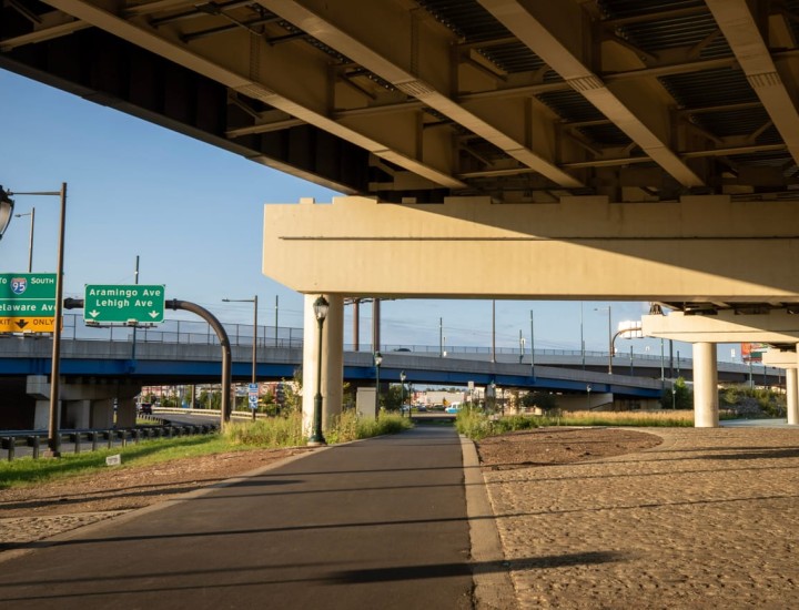 Clear paved walking path under I-95 overpass