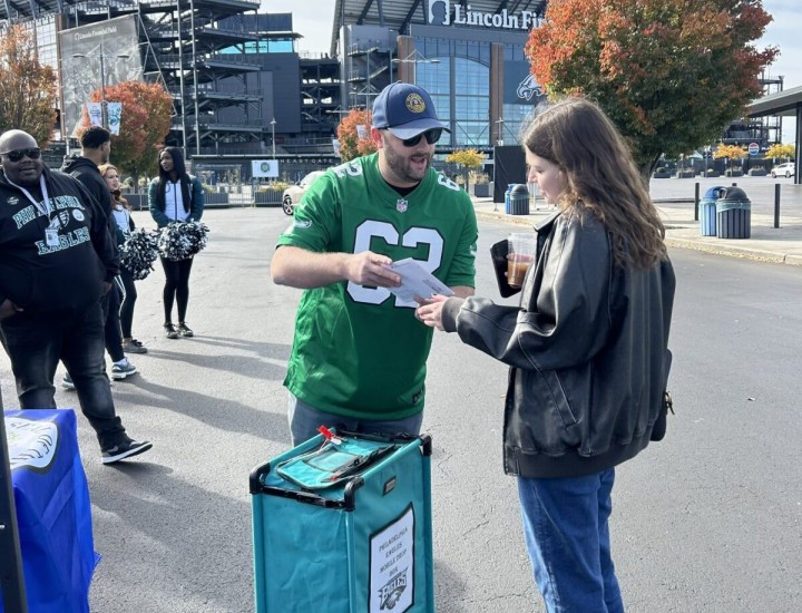 Two people talking at a mail ballot drop off event at Lincoln Financial Field