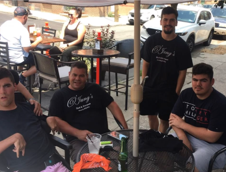 Louis Jung and three sons around an outdoor restaurant table